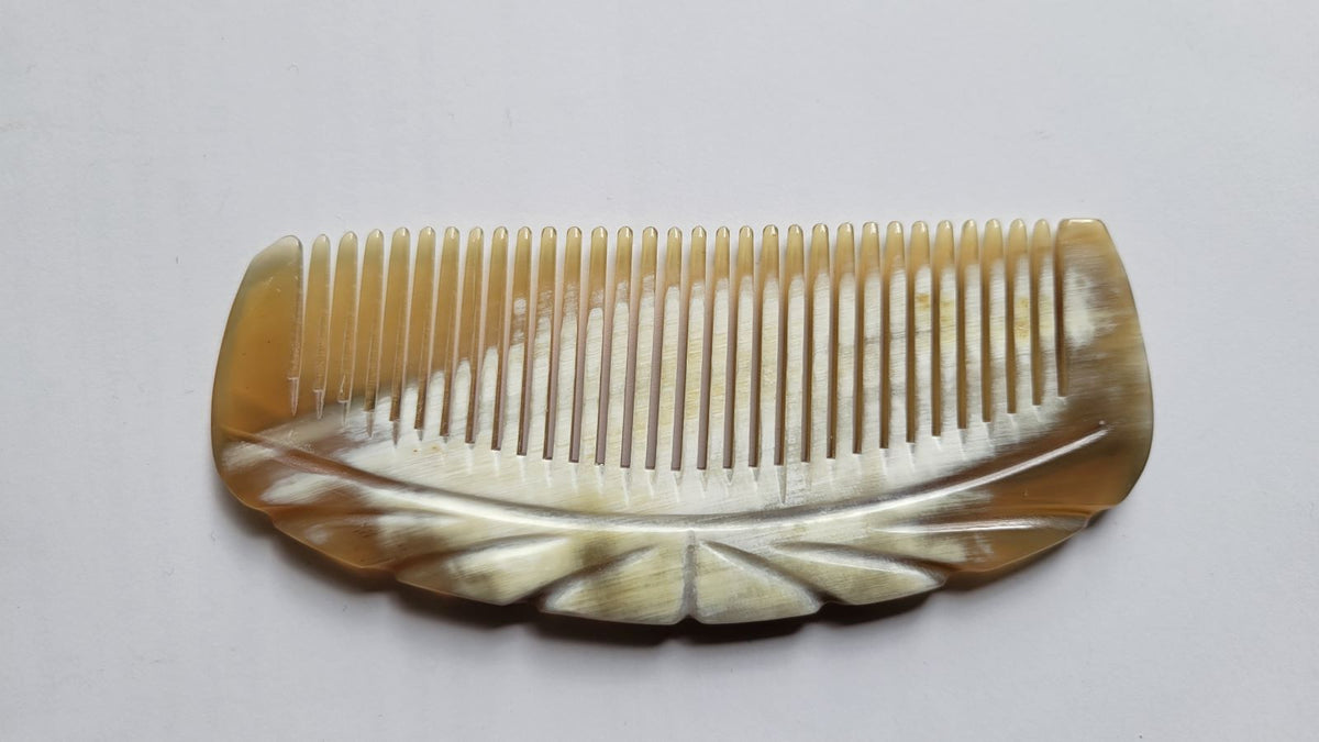 Deep amber yak horn comb spine with engraved fan carving, natural dark streaks, single-piece horn construction | Arakicrafts